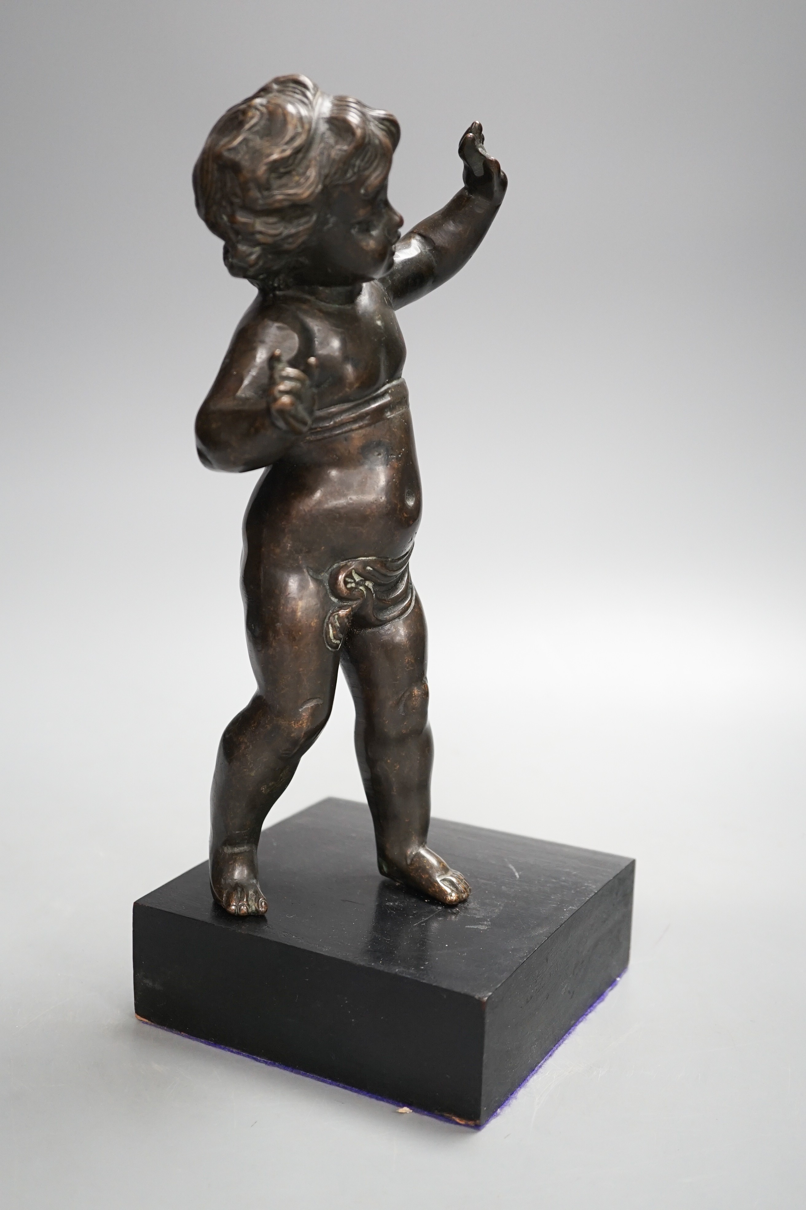 A 20th century bronze putto on wooden stand 29cm including stand